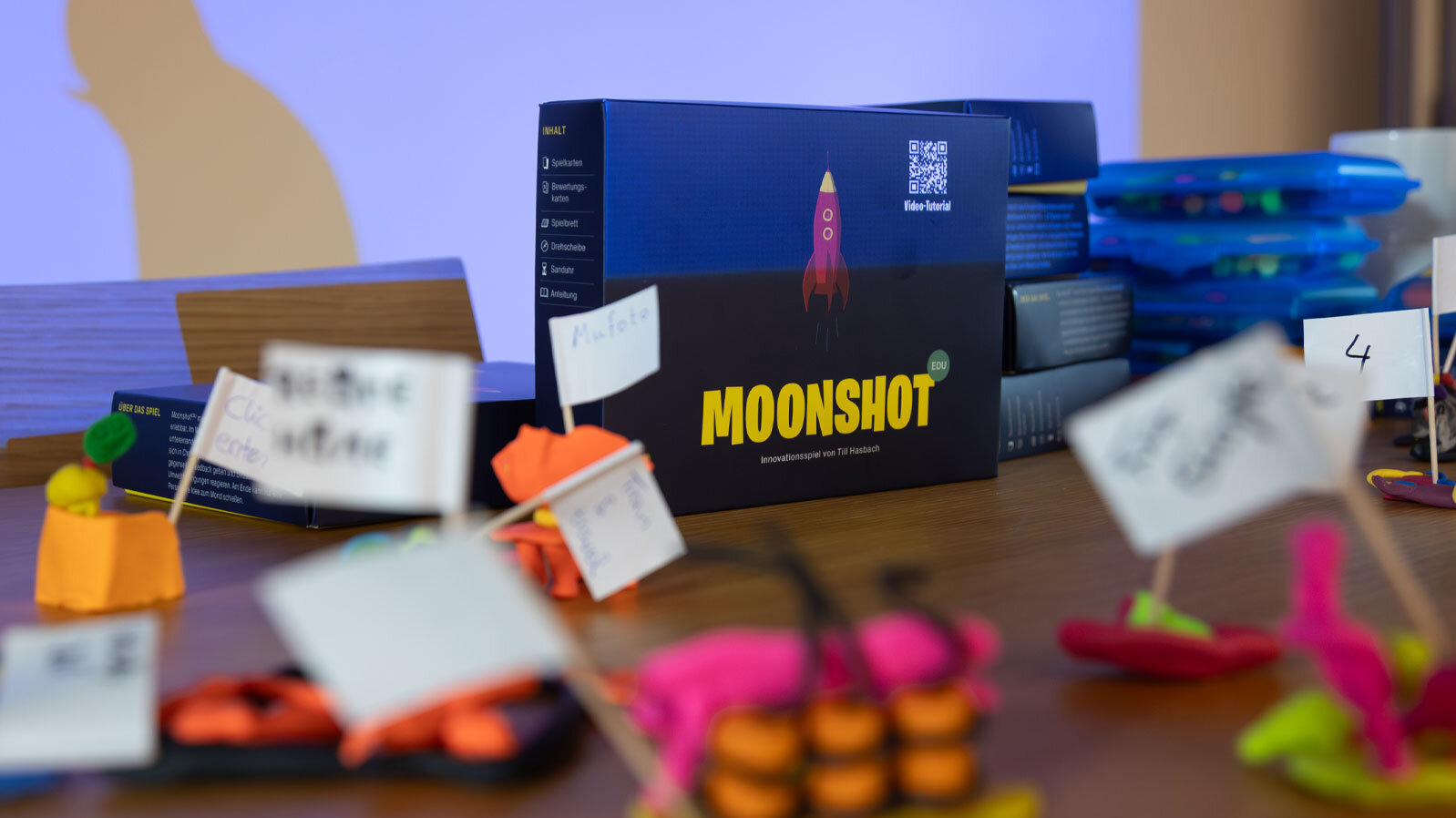 Auf einem Tisch steht das Lernspiel Moonshot mit einigen der Spielelemente.