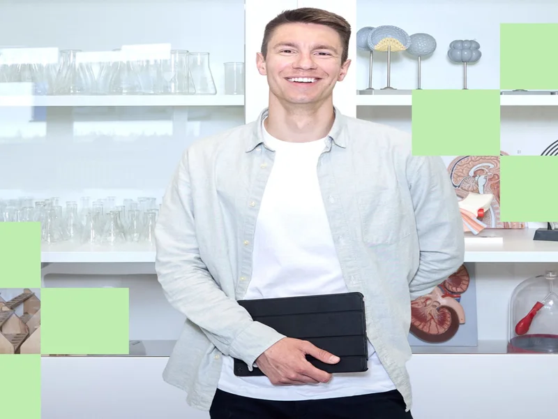 Lehrkraft Sebastian Engel steht im Biologieraum vor einer Glasvitrine und schaut in die Kamera.