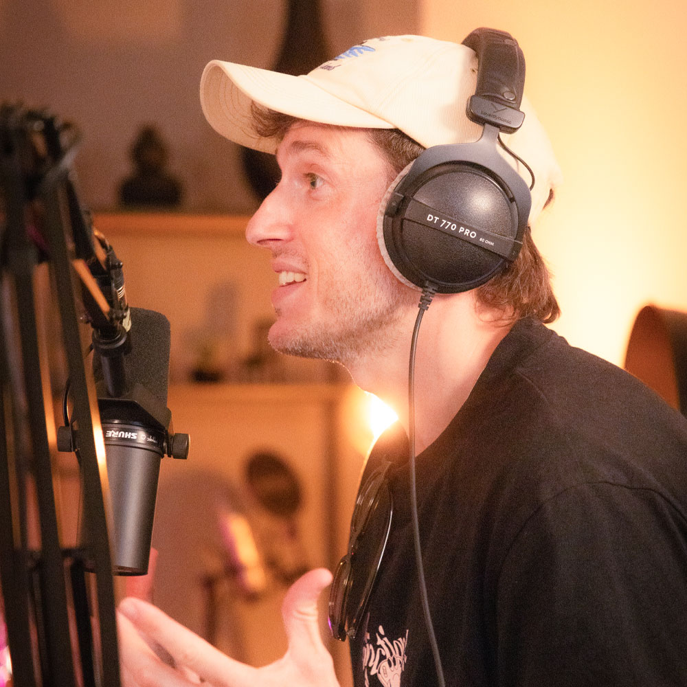 Chris Bush am spricht während der Podcastaufnahme ins Mikrofon