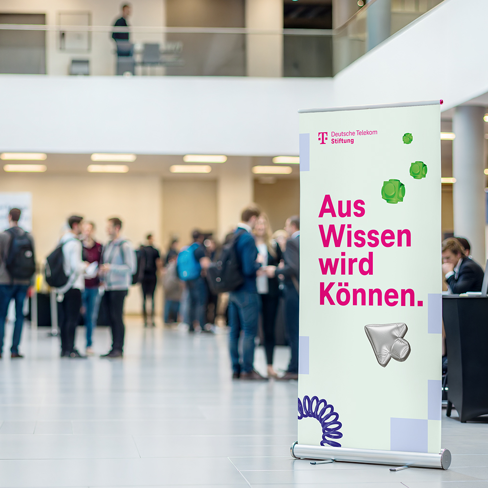 Ein Banner im neuen Design der Stiftung steht im Eingangsbereich eines Gebäudes